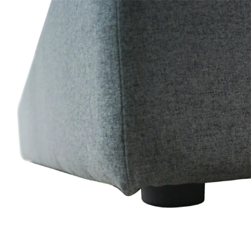 Close-up of a gray upholstered chair corner on a white background