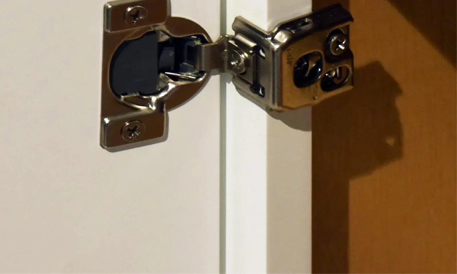 Concealed soft-close hinge on a white cabinet door