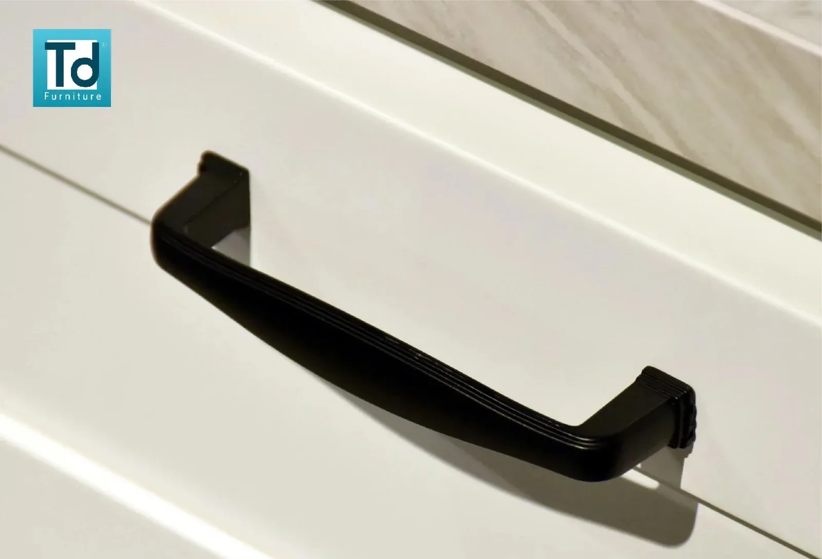 Matte black bar handle mounted on a white drawer front