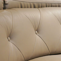 Close-up of beige leather sofa with tufted backrest