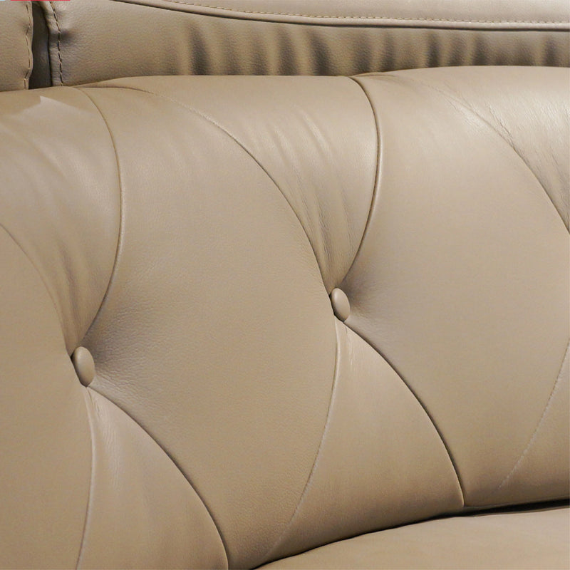 Close-up of beige leather sofa with tufted backrest