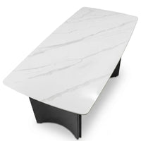 Modern coffee table with white marble-like top and black base on a white background