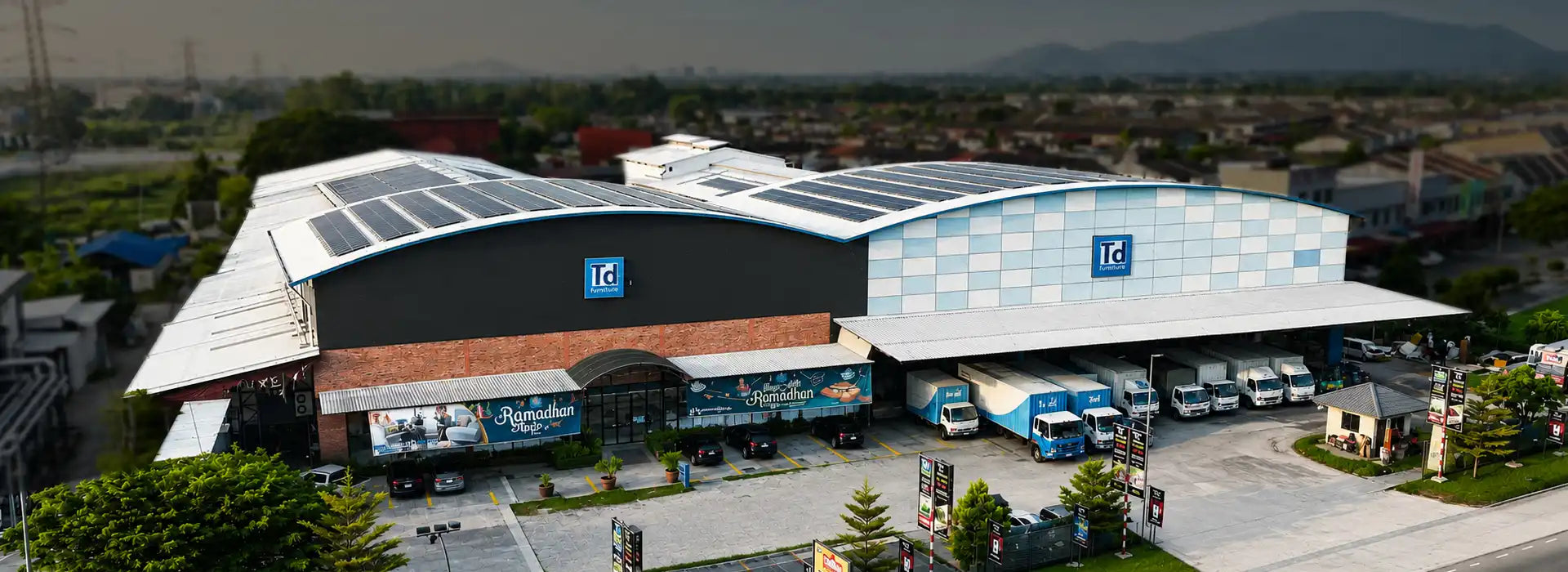 A large industrial building with solar panels on the roof, featuring the ID logo.
