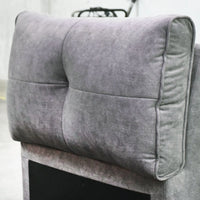 Gray upholstered headboard on a bed with a blurred background