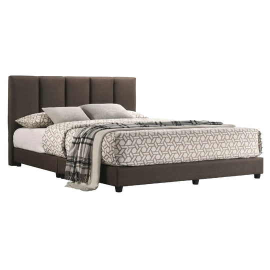 Bed with brown upholstered headboard and geometric bedding on a white background