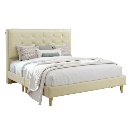 Beige upholstered bed with bedding on a white background