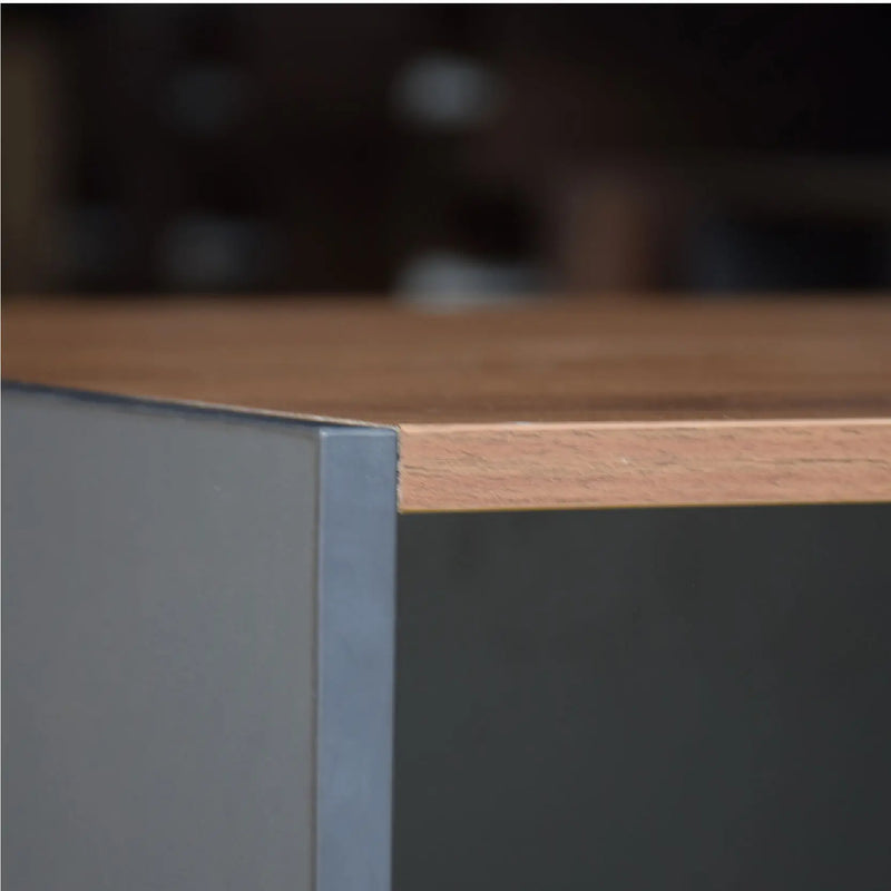 Close-up of a wooden desk with a metallic corner detail, blurred background