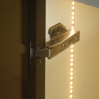 Close-up of a metallic hinge on a door with LED strip lighting.