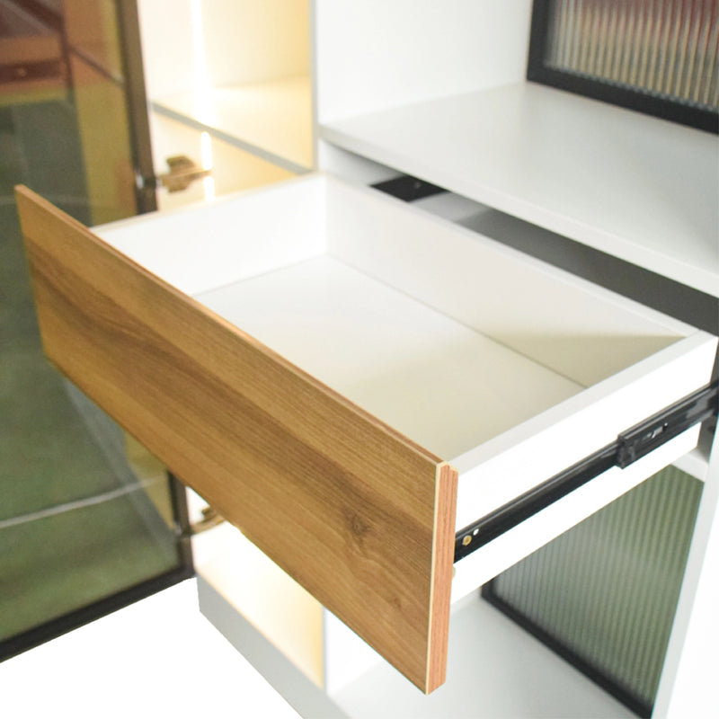 Wooden drawer being pulled out from a white cabinet with a blurred background