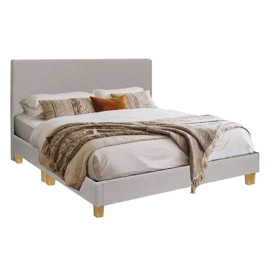 Beige upholstered bed with white bedding and patterned pillows on a white background