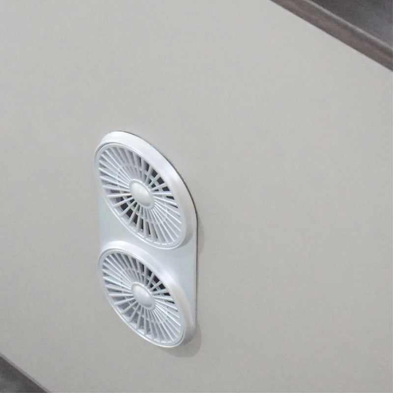 White portable fan attached to a light gray wall