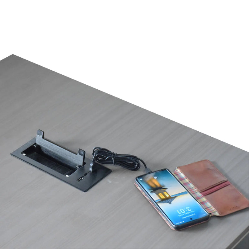 Smartphone with wallet and cable on a desk next to a computer monitor stand.